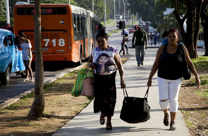 Dos mujeres cargan una bolsa después de llegar en autobús a La Habana, Cuba, el jueves 27 de junio de 2019.&nbsp;