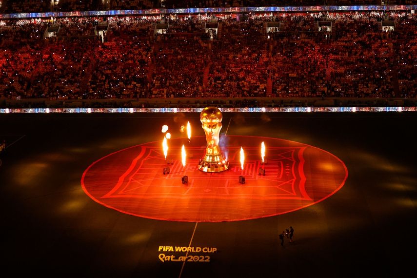 Una réplica del trofeo de la Copa Mundial de la FIFA se muestra en la cancha mientras los fuegos artificiales estallan antes del partido de fútbol del Grupo A de la Copa Mundial de Catar 2022 entre Catar y Ecuador en el Estadio Al-Bayt en Al Khor, al norte de Doha el 20 de noviembre de 2022.