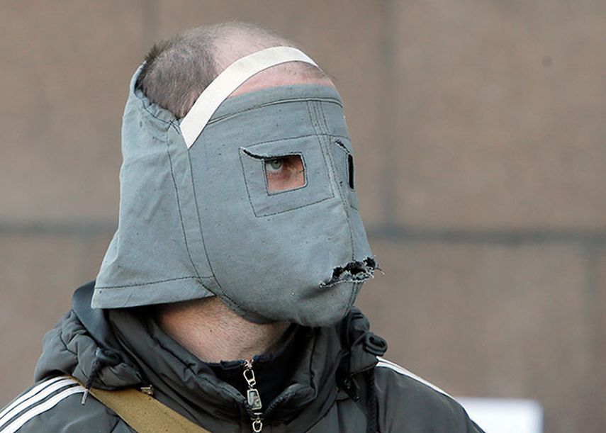 Un activista prorruso con una máscara detrás de una barricada frente al edificio de administración regional en Donetsk, Ucrania. (Foto AP/Efrem Lukatsky)