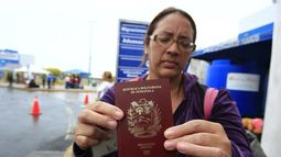 Una mujer venezolana muestra su pasaporte.