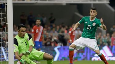 Keylor Navas, arquero de Costa Rica, intenta detener un disparo de Néstor Araujo, de México, en un partido de la eliminatoria mundialista