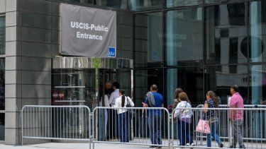Imagen referencial de personas llegando a un edificio de USCIS para realizar trámites migratorios.