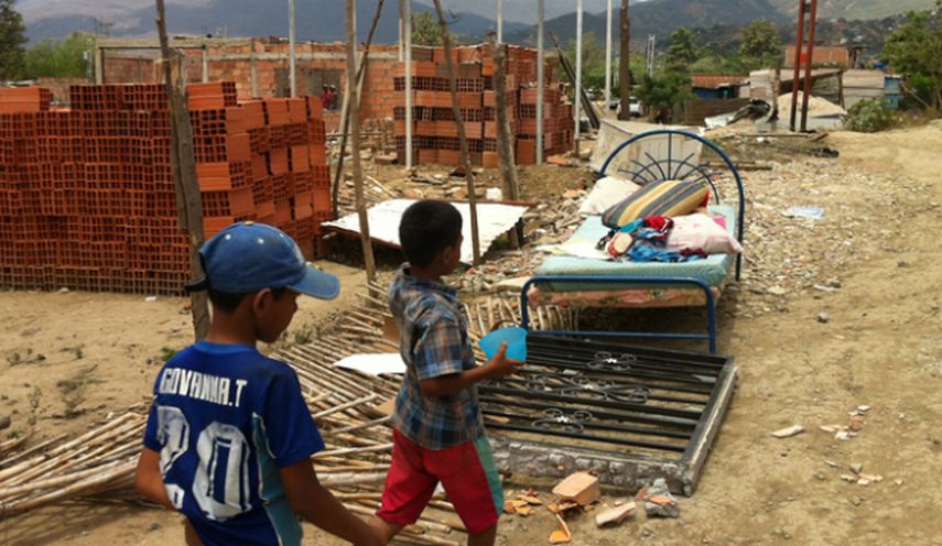 En la imagen se ve a Brayan y su hermano Kevin tratando de recuperar sus pertenencias en su antiguo hogar en San Antonio del Táchira. (CORTESÍA/La Opinión)