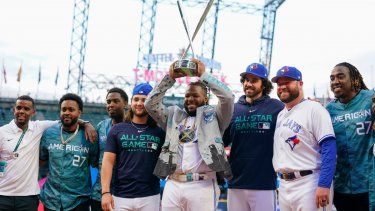 Vladimir Guerrero Jr., de los Azulejos de Toronto, alza el trofeo que lo acredita como campeón del Derby de Jonrones, mientras es rodeado por sus compañeros, en Seattle, el lunes 10 de julio de 2023.&nbsp;