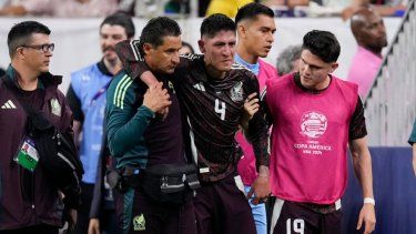 El volante mexicano Edson Álvarez (centro) se retira lesionado durante el partido de México contra Jamaica por el Grupo B de la Copa América, el sábado 22 de junio de 2024, en Houston.&nbsp;