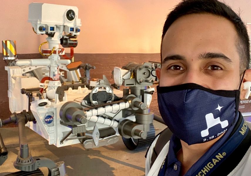 Esta imagen ofrecida por Elio Morillo muestra al ingeniero de La Administración Nacional de Aeronáutica y el Espacio (NASA) posando junto a un modelo del Perseverance en un laboratorio de la agencia espacial en Pasadena, California, el 17 de febrero del 2020