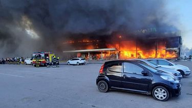 Bomberos tratan de extinguir las llamas en un centro comercial que ardió luego de ser impactado por un misil, en Kremenchuk, Ucrania, el lunes 27 de junio de 2022.