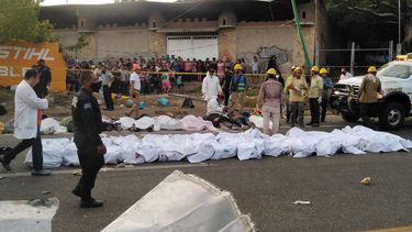 Parte de los migrantes fallecidos en accidente tendidos en la acera en Tuxtla Gutiérrez, estado de Chiapas, México, el 9 de diciembre de 2021.