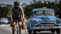 Un ciclista con máscara como medida de precaución contra la propagación del nuevo coronavirus lleva un pollo en la mano mientras pedalea su bicicleta en La Habana, Cuba, el domingo 11 de octubre de 2020. 