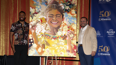 El autor del póster, el artista conocido como Mojo, posa junto a su obra, Our Heartbeat, y al presidente del Club de los Kiwanis de la Pequeña Habana, Pablo Lau. 
