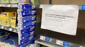 Un letrero que informa a los consumidores sobre los límites en la compra de fórmula láctea cuelga a la orilla de un anaquel vacío para el producto en la tienda King Soopers, 12 de mayo de 2022, en Denver.