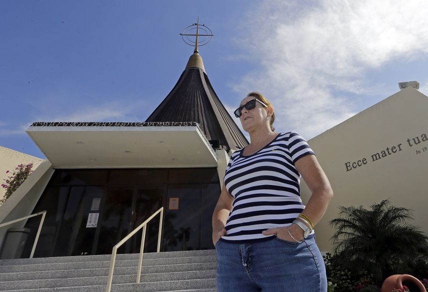 En la gráfica, la cubano-estadounidense Larisa Alonso posa ante la Ermita de la Caridad en Miami. (AP)