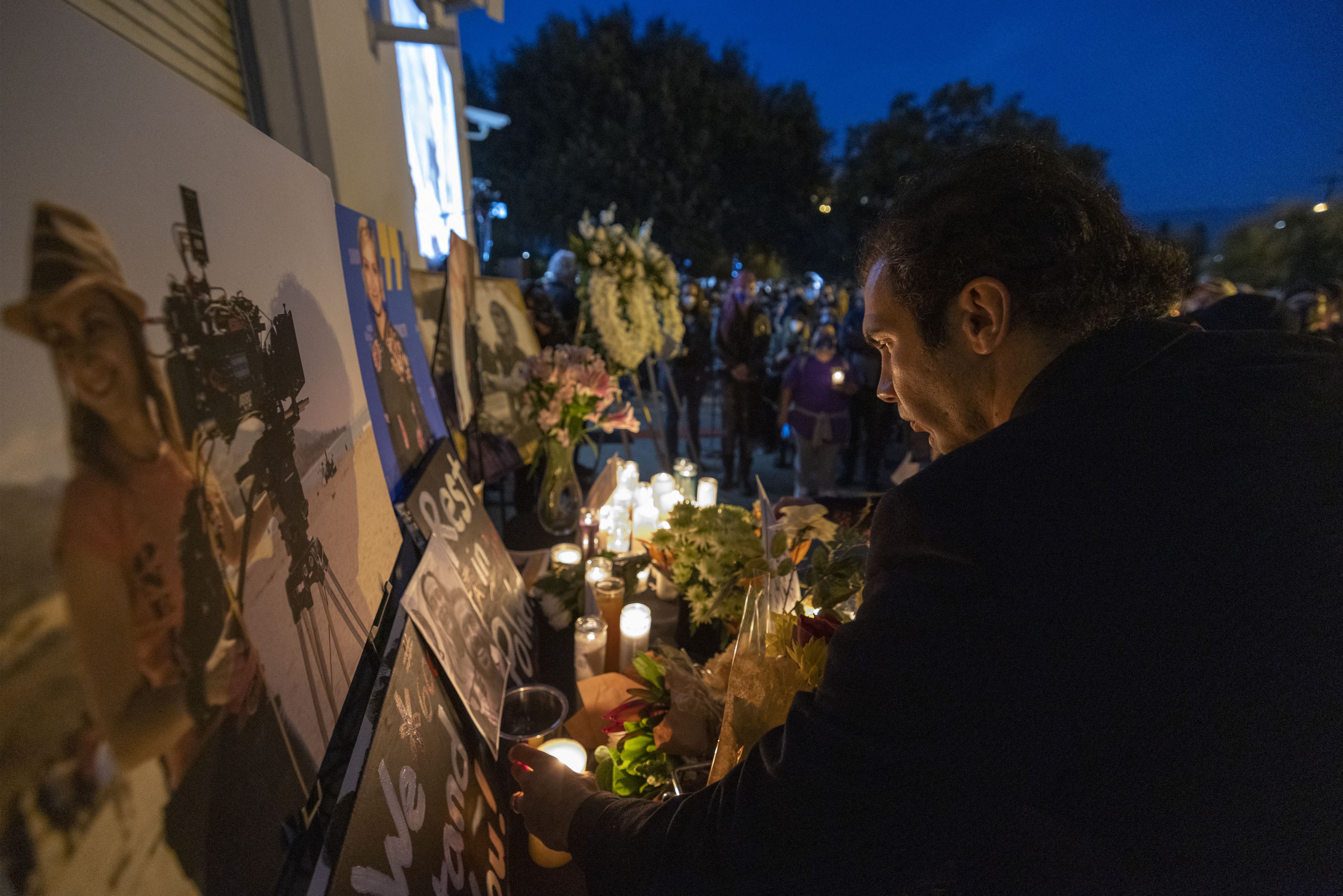 Un hombre rinde homenaje cerca de una foto de la directora de fotografía Halyna Hutchins, quien murió accidentalmente por un arma de utilería disparada por el actor Alec Baldwin, en una mesa conmemorativa durante una vigilia a la luz de las velas en su memoria en Burbank, California, el 24 de octubre de 2021. Un hombre rinde homenaje cerca de una foto de la directora de fotografía Halyna Hutchins, quien murió accidentalmente por un arma de utilería disparada por el actor Alec Baldwin, en una mesa conmemorativa durante una vigilia a la luz de las velas en su memoria en Burbank, California, el 24 de octubre de 2021.