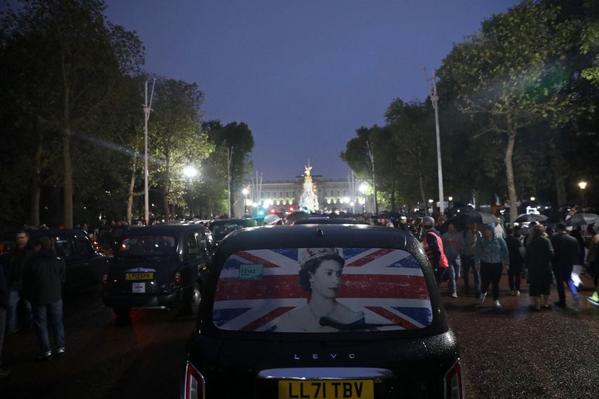 Un taxi que muestra una fotografía de la reina atraviesa multitudes de simpatizantes en The Mall mientras la gente se reúne fuera del Palacio de Buckingham, después del anuncio de la muerte de Isabel II, en el centro de Londres el 8 de septiembre de 2022.&nbsp;