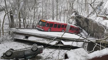 Un autobús de la Autoridad Portuaria y otro automóvil que estaban en un puente cuando se derrumbó el viernes 28 de enero de 2022 son visibles en el East End de Pittsburgh. Cuando el puente se derrumbó, los rescatistas descendieron casi 150 pies mientras otros formaban una cadena humana para ayudar a rescatar a varias personas del autobús que colgaba.&nbsp;