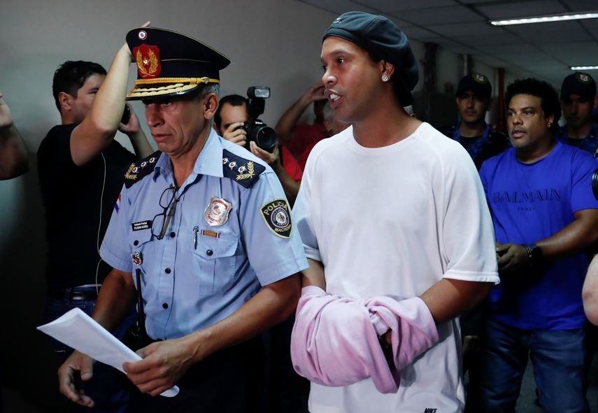 &nbsp; El ex astro brasile&ntilde;o de f&uacute;tbol Ronaldinho camina esposado a una audiencia judicial en Asunci&oacute;n, Paraguay, el s&aacute;bado, 27 de marzo del 2020.&nbsp; &nbsp;
