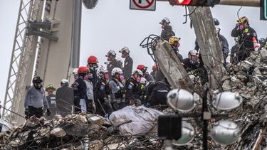 Personal rescate trabaja bajo la lluvia en la pila de escombros del condominio Champlain Towers South de 12 pisos, que colapsó el 24 de junio de 2021.