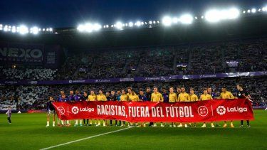 Los jugadores levantan una pancarta que dice Racistas fuera del fútbol antes de un partido de fútbol de la Liga española entre el Real Madrid y el Rayo Vallecano en el estadio Santiago Bernabéu en Madrid, España, el miércoles 24 de mayo de 2023.&nbsp;