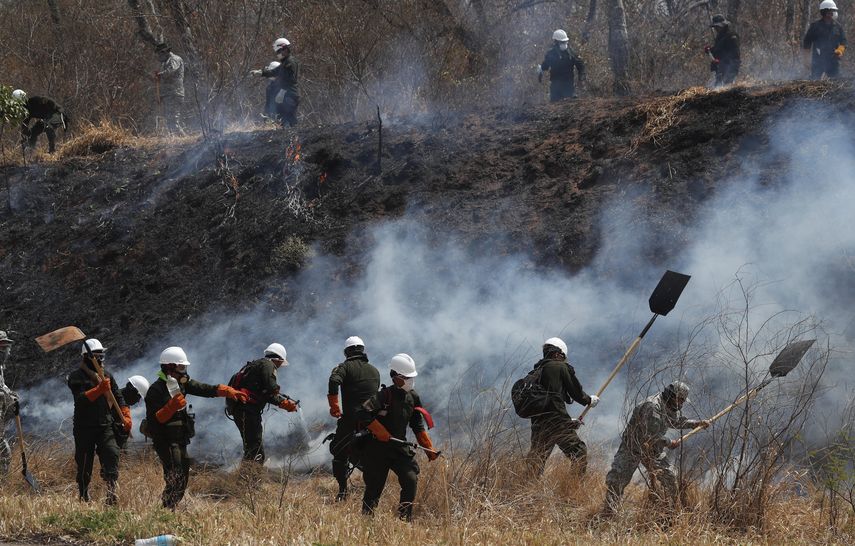 Polic&iacute;as y bomberos trabajan para apagar un incendio en el bosque de Chiquitan&iacute;a, en las afueras de Robor&eacute;, Bolivia, el viernes 30 de agosto de 2019. La Uni&oacute;n Europea, Estados Unidos y otros pa&iacute;ses prometieron m&aacute;s ayuda para combatir los incendios forestales que afectan desde hace dos meses a Bolivia.