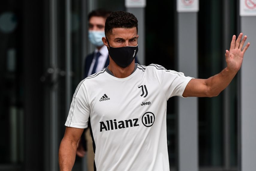 Cristiano Ronaldo, saluda a los aficionados al salir del centro médico de la Juventus en Turín tras su reconocimiento médico, el 26 de julio de 2021