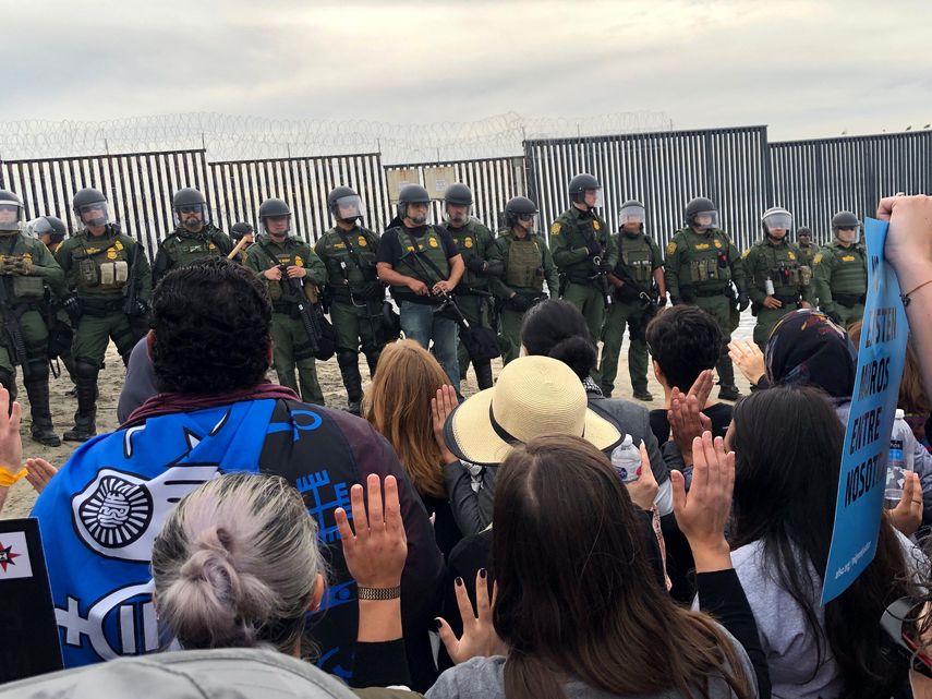 Un grupo de manifestantes, en su mayoría religiosos, se confronta a miembros del Servicio de Protección Federal (FPS) durante un acto de desobediencia civil en apoyo a la caravana migrante hoy, cerca del&nbsp;muro&nbsp;fronterizo&nbsp;entre Tijuana y San Diego.