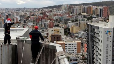 Unos trabajadores limpiando un edificio en Quito. (REUTERS)