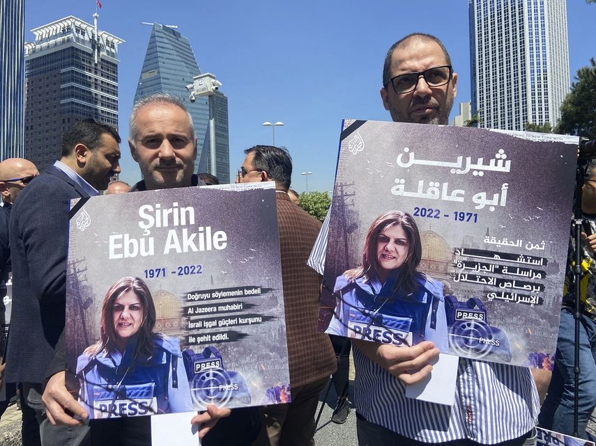 Dos hombres con carteles asisten a una concentración propalestina frente al consulado israelí en Estambul para denunciar la muerte de la periodista Shireen Abu Akleh, de la televisora Al Jazeera, 12 de mayo de 2022.&nbsp;