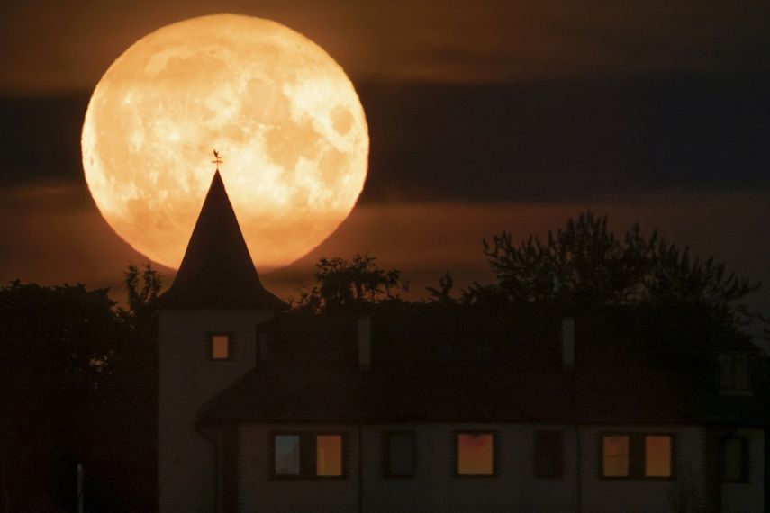 La luna lleva se eleva sobre una vivienda en la localidad de Putilovo, a 70 kilómetros (43 millas) al este de San Petersburgo, Rusia, el 13 de julio de 2022.&nbsp;