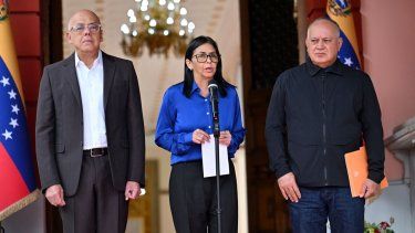 La jefa encargada de Venezuela, Delcy Rodríguez (centro), habla junto al presidente de la Asamblea Nacional, Jorge Rodríguez (I), y el ministro del Poder Popular para Interior, Diosdado Cabello, durante una conferencia de prensa en el Palacio Presidencial de Miraflores en Caracas, el 14 de enero de 2026.