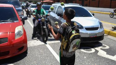 Un niño hace malabares en plena avenida del centro de Caracas para buscar algún dinero.&nbsp;