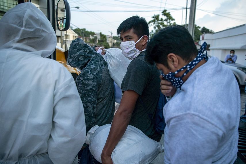 Guatemaltecos deportados por Estados Unidos, usando mascarillas para prevenir el coronavirus, abordan un autob&uacute;s tras llegar al Aeropuerto La Aurora, en Ciudad de Guatemala, el 9 de junio de 2020.&nbsp;