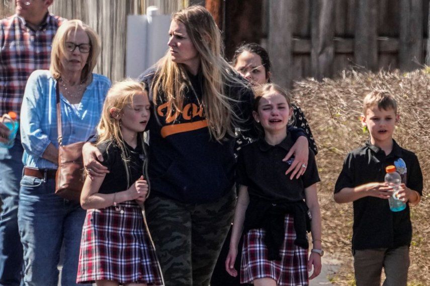 Niños y una mujer salen del centro de reunificación en la iglesia Bautista Woodmont después de un tiroteo en una escuela, el 27 de marzo de 2023, en Nashville, Tennessee.