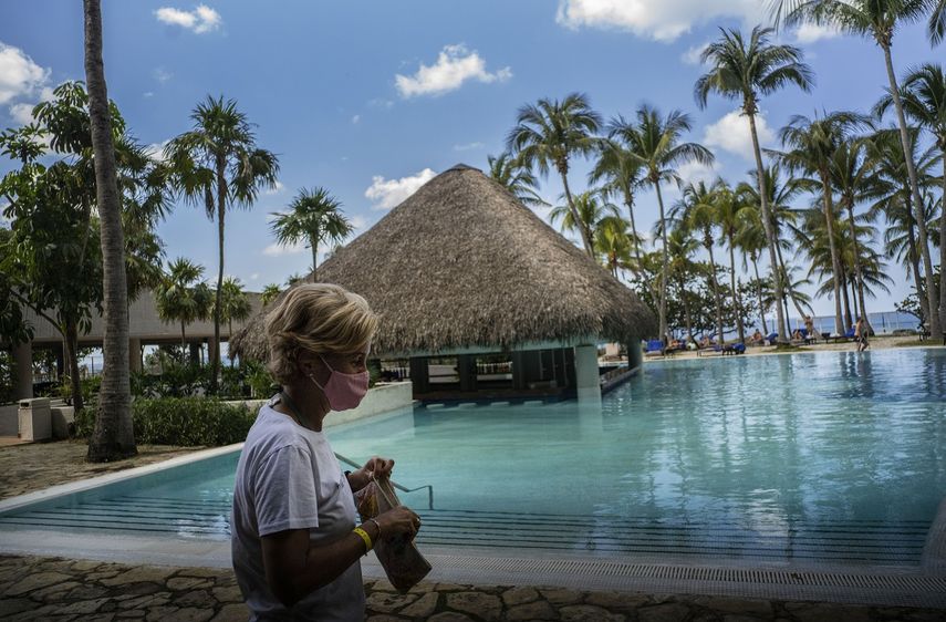 Con una máscara contra la propagación del nuevo coronavirus, una turista camina por el área de la piscina del hotel Meliá Habana en La Habana, Cuba, el jueves 11 de febrero de 2021.&nbsp;