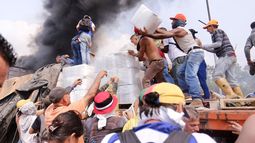 Voluntarios rescatan las cajas con la ayuda humanitaria que fue quemada por grupos irregulares a disposición del régimen de Nicolás Maduro.&nbsp;