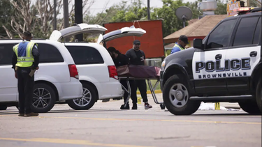 Las autoridades levantan a una de las víctimas que murió  tras ser embestidas por un auto, en Brownsville, Texas.