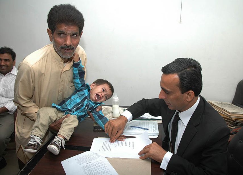 Foto tomada el 3 de abril pasado donde un juez pakistaní toma las huellas del niño de nueve meses que fue acusado de intento de homicidio. (AP)
