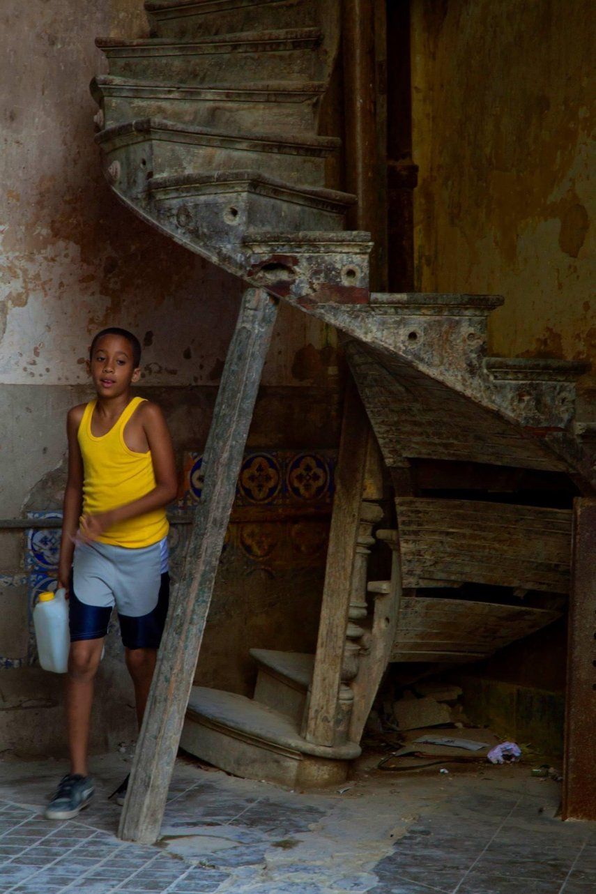 Un niño sale de un edificio en peligro de derrumbe en Centro Habana en busca de agua.&nbsp;