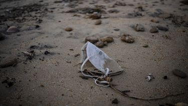 Una mascarilla protectora contra el coronavirus está tirada en una playa cerca de Barbate, provincia de Cádiz, sur de España, 5 de febrero de 2022. El gobierno español anunció el martes 8 de febrero de 2022 que anulará la orden de utilizar la mascarilla en el exterior en momentos que caen las tasas de trasmisión del COVID-19 y los hospitales reportan menos internaciones.&nbsp;