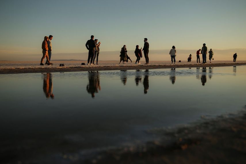 Curiosos caminan por el lecho seco del Lago Tuz en el centro de Turquía el 26 de octubre del 2021. Solo se ve una pequeña faja de agua poco profunda en el segundo lago más grande del país.