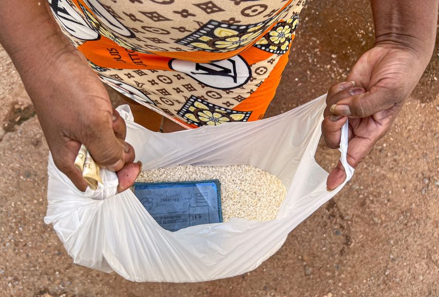 Una mujer cubana muestra una bolsa con el arroz mensual de la familia al salir de un almacén en La Habana, el 17 de septiembre de 2024.