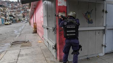 Un miembro de la Policía Nacional Bolivariana apunta a un posible objetivo luego de enfrentamientos con presuntos miembros de una banda criminal en el barrio Cota 905, en Caracas, el 9 de julio de 2021&nbsp;