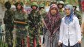 Mujeres de la etnia uigur vigiladas por militares chinos. Mujeres de la etnia uigur vigiladas por militares chinos.