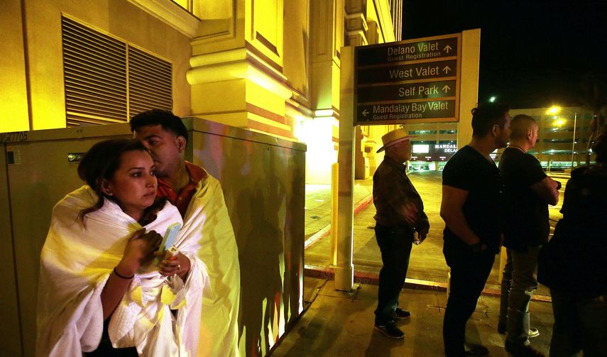 Varias personas permanecen a la entrada del hotel Mandalay Bay, cerca del lugar donde se produjo un tiroteo indiscriminado la pasada noche en Las&nbsp;Vegas, Estados Unidos, hoy, 2 de octubre de 2017.