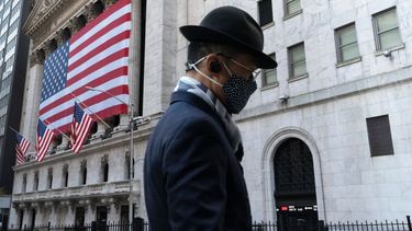 Un hombre con mascarilla pasa frente a la Bolsa de Valores de Nueva York.