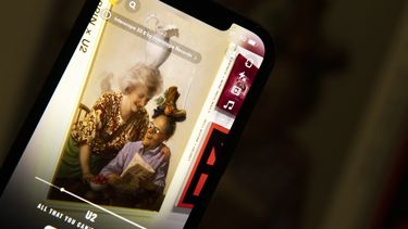 La pantalla de un teléfono móvil muestra U2 Beautiful Day.