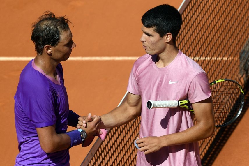 El español Rafael Nadal le da la mano a su compatriota Carlos Alcaraz después de un partido en Madrid