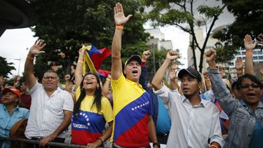 Simpatizantes del presidente interino de Venezuela, Juan Guaidó, levantan la mano para mostrar su aprobación al hecho de que su país se reintegre al Tratado Interamericano de Asistencia Recíproca (TIAR), según decidió la Asamblea Nacional, mientras lo escuchan hablar en Caracas. 