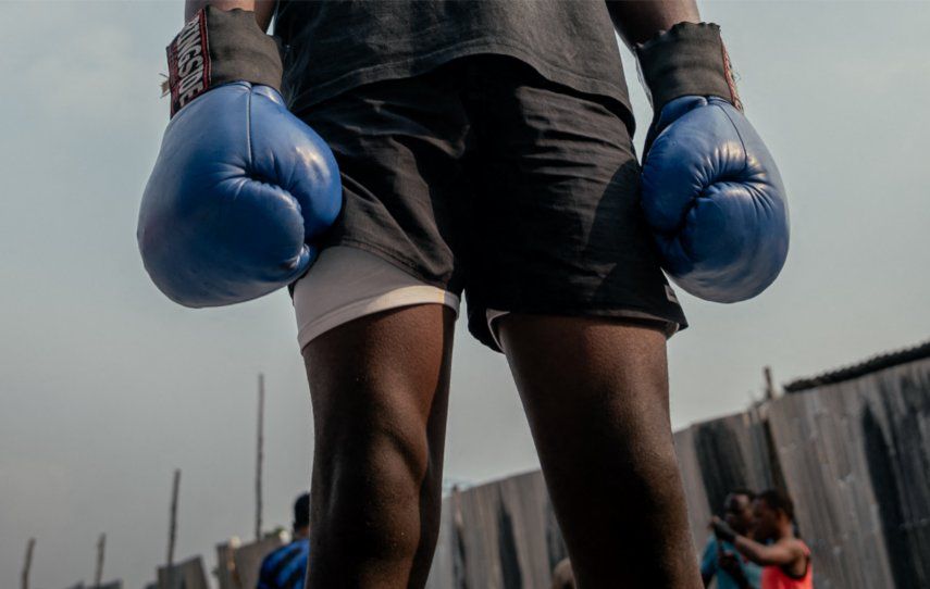 Un joven boxeador del Club Virunga escucha las instrucciones de su entrenador durante un descanso entre asaltos en una sesión de sparring matutina en Goma el 13 de julio de 2025.