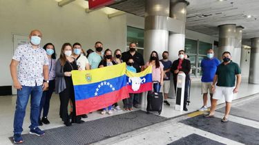Esta foto proporcionada por Cristina Mujica muestra a ciudadanos venezolanos sosteniendo la bandera de su pa&iacute;s en el Aeropuerto Internacional de Miami en julio de 2020 donde est&aacute;n varados, incluida Mujica.&nbsp;
