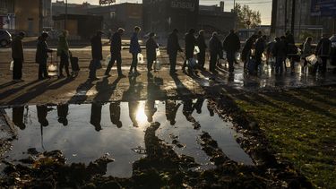 Unas personas se forman para llenar botellas de plástico con agua potable de un tanque en el centro de Mykolaiv, Ucrania, el lunes 24 de octubre de 2022.&nbsp; 
